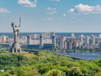 motherland monument among green trees on embankment in kiev