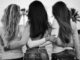 grayscale and selective focus photography of three women